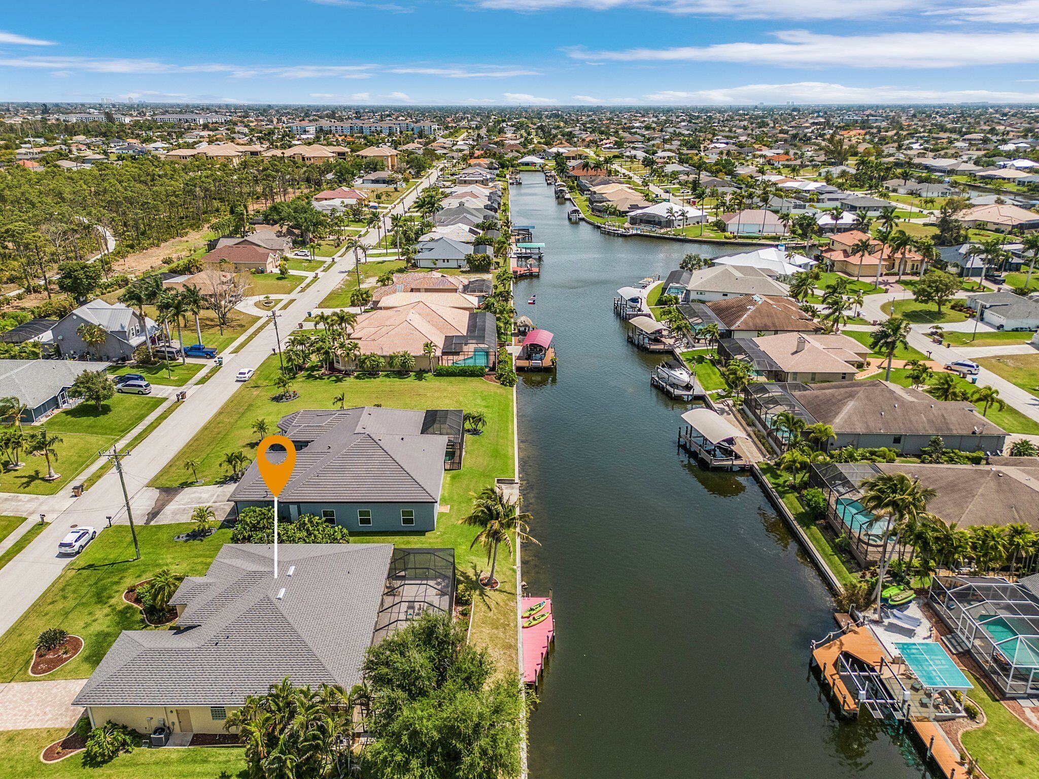 A residential area with a canal, houses, and a boat dock.