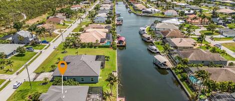 A residential area with a canal, houses, and a boat dock.