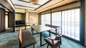 A traditional Japanese room with tatami flooring, a low table, and sliding doors. - Kinosaki Onsen Yuyado Sasakura (Toyooka)