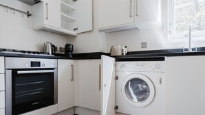 Eine moderne Küche mit Backofen von Bosch, einer Waschmaschine und einer Kaffeemaschine.