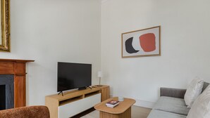 Ein modernes Wohnzimmer mit Fernseher, Kamin, Sofa und Couchtisch.