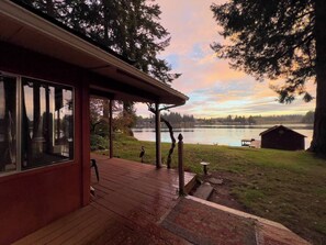 A wooden deck with a view of a lake and a small dock. - Escape to our 2BR Long Lake waterfront home with private dock, direct lake access, and serene views. (Olympia)