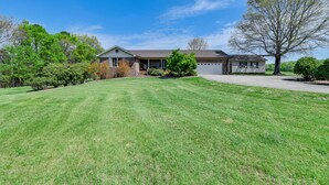 A single-story house with a front yard, garage, and a large tree. - Spacious Mount Pleasant Home w/ Grill & Yard! (Mt Pleasant)