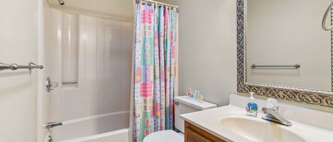 A bathroom with a bathtub, toilet, and sink.