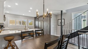A modern kitchen with a central island, stainless steel appliances, and a chandelier. - Amelia Island 2BR Renovated Townhome near the Ritz Carlton - Sandpiper VIlla (Fernandina Beach)