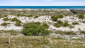 A sandy beach with sparse vegetation and a wooden boardwalk leading to the ocean. - Amelia Island 2BR Renovated Townhome near the Ritz Carlton - Sandpiper VIlla (Fernandina Beach)