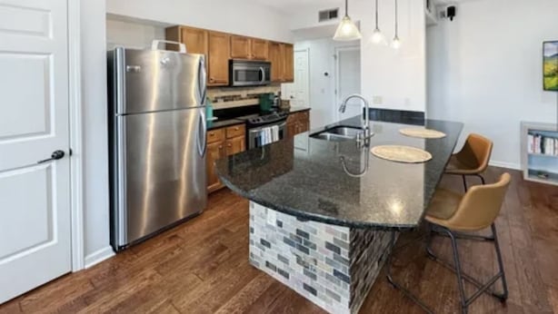 A modern kitchen with a central island, stainless steel appliances, and wooden flooring. - BLUES LANDING
The best stay between Main and the Mississippi!! (Memphis)
