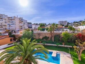 A pool area with palm trees, a white fence, and a view of surrounding buildings. - Sotomar - Terrace, Swimming Pool, Carihuela (Torremolinos)