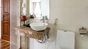 A bathroom with a marble countertop, a white sink, a mirror, and a toilet. - La Palma Boutique Hotel (Ho Chi Minh City)