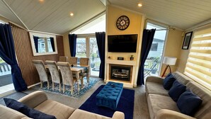 A cozy living room with a fireplace, comfortable seating, and a TV. - Sunset 5 -  Southview Holiday Park Skegness (Skegness)