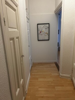 Stylish hallway with artwork and doors leading to further rooms.