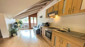 A modern kitchen with wooden cabinets, a built-in oven, and a large window.