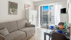 Ein modernes Wohnzimmer mit Sofa, Esstisch und Balkon mit Blick.