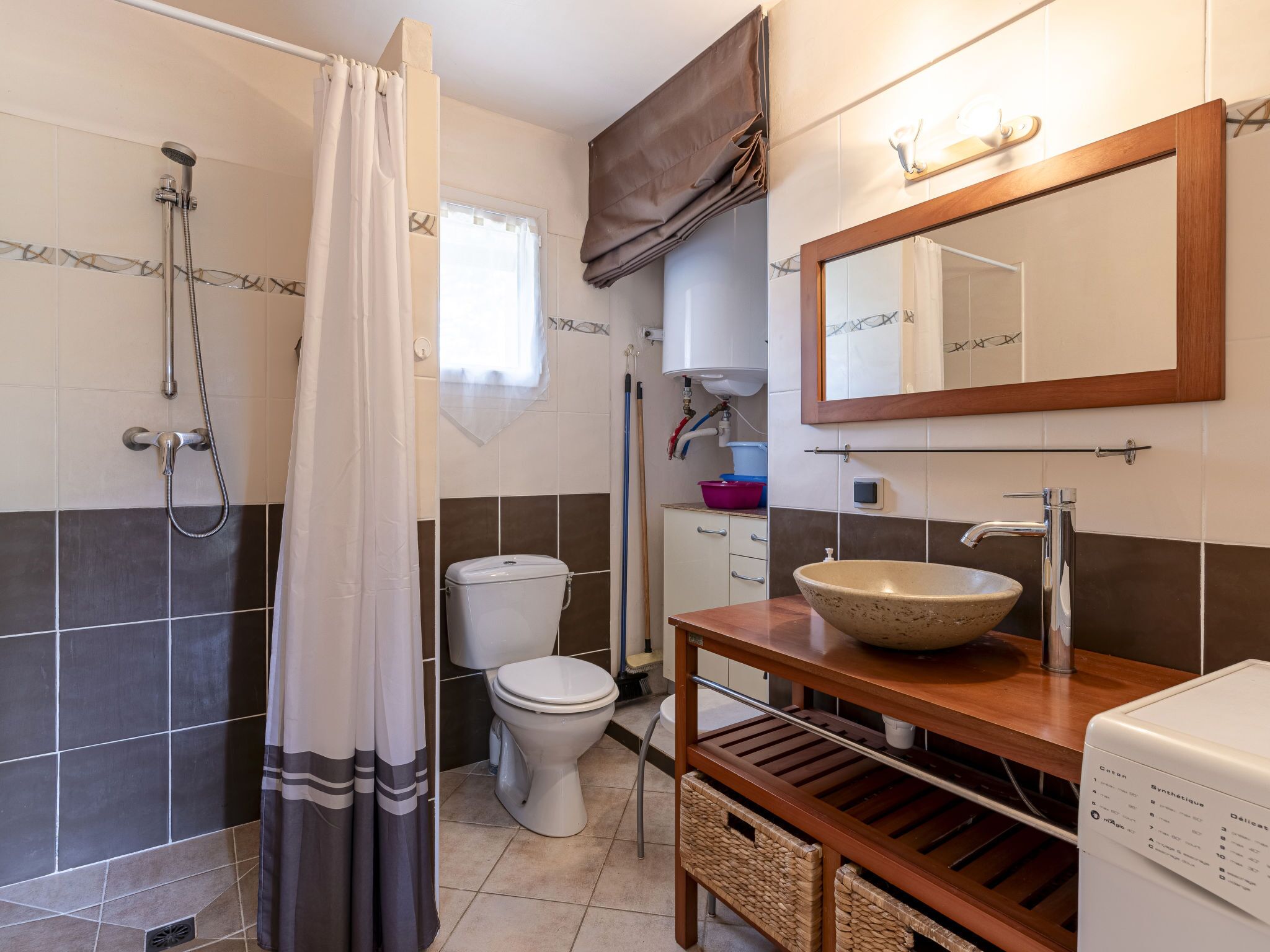 Un baño con ducha, inodoro, lavabo y espejo.