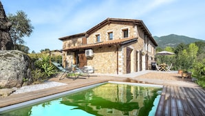 A stone house with a swimming pool, outdoor furniture, and a view of the mountains. - Vacation home Mela by Interhome (Porto Vecchio)