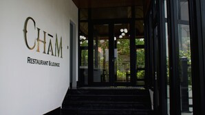 A modern entrance with a wooden ceiling and glass doors leading to a garden area. - Indigen Boutique Hotel Cao Bang (Thuc Phan)
