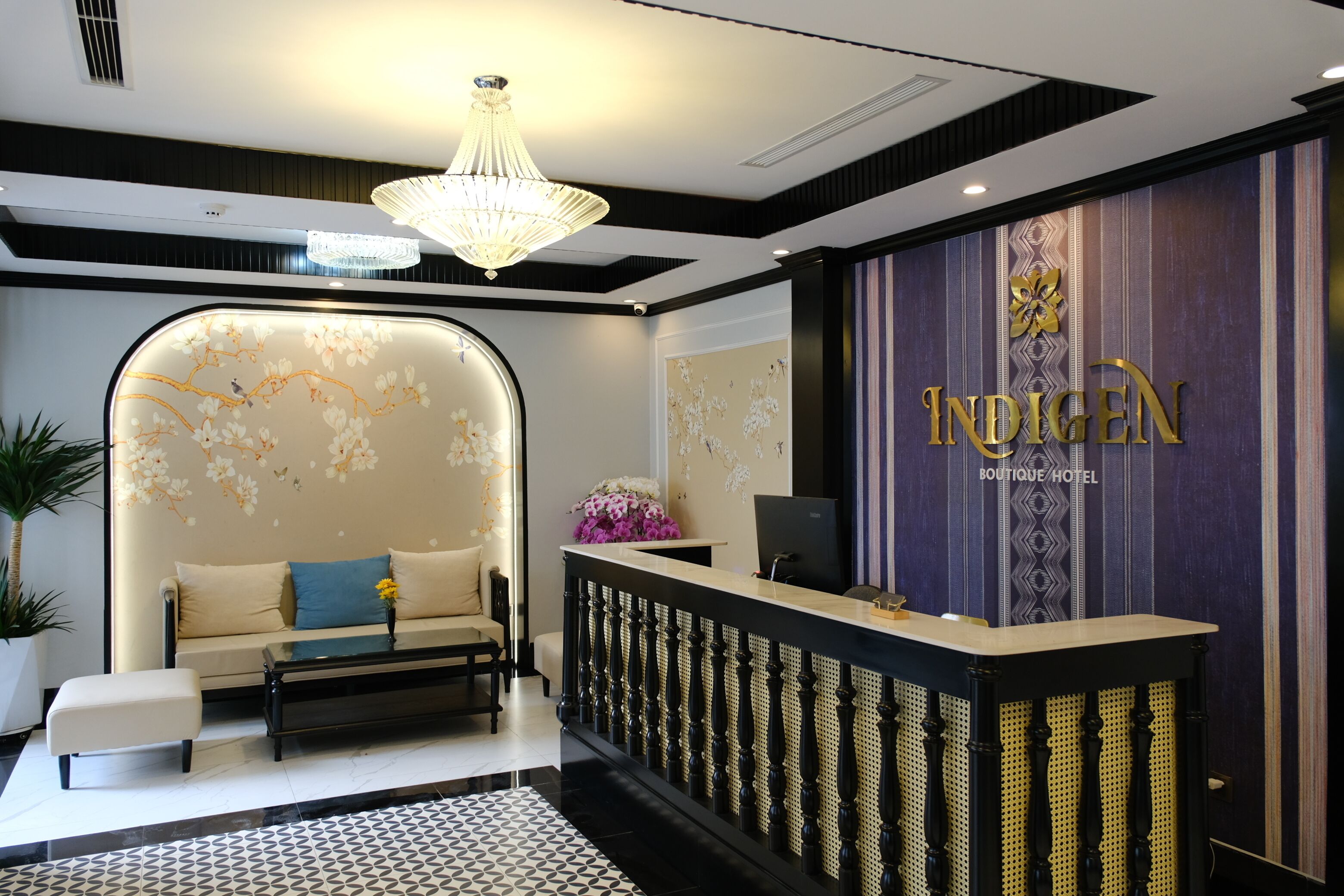 A reception area with a sofa, a reception desk, and a chandelier.