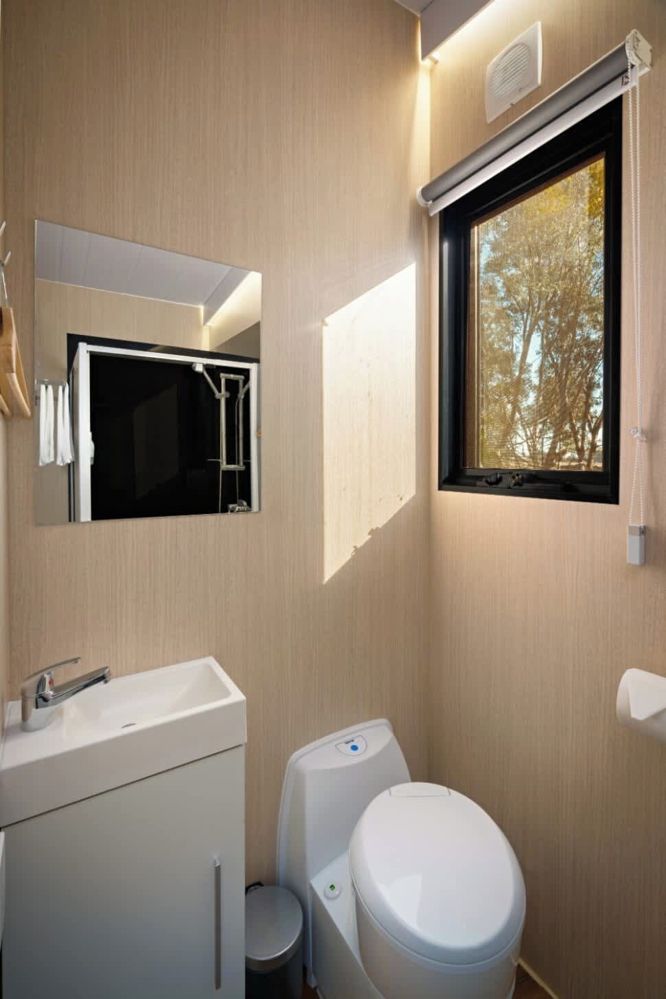 A modern bathroom with a sink, toilet, and mirror.