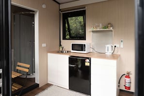 A compact kitchen with a microwave, coffee maker, and a fire extinguisher. - Sweet Hart 2 by Tiny Away (Tamahere)