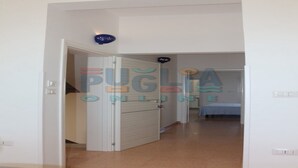 A hallway leading to a bedroom with a bed and a nightstand. - Vacation home La Perla Salentina (Marina di Capilungo)