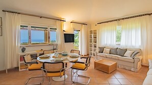 Una sala de estar amplia con comedor, sofá y televisor.