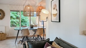 A dining area with a table, chairs, and pendant lights.