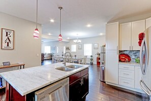 A modern kitchen with a central island, stainless steel appliances, and pendant lighting.