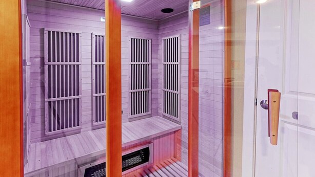 Una sala de sauna con bancos de madera y barras de metal.