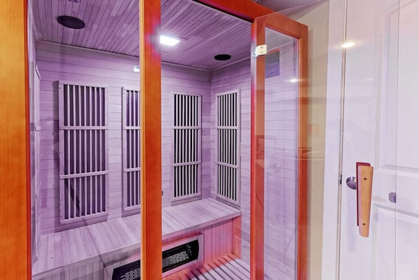 Una sala de sauna con bancos de madera y barras de metal.