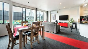 A modern hotel room with a dining area, a living space, and a kitchen. - Auckland Penthouse: SkyTower Views. Special Offer (Auckland)