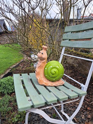 A bench with a snail sculpture. - Pension Andrea: Apartment 3 with Wi-Fi (Herbstein)
