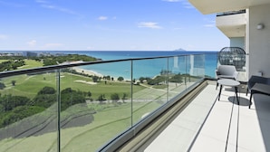 Ein Balkon mit freiem Blick auf den Ozean, einen Golfplatz und ein ferneres Gebirge.