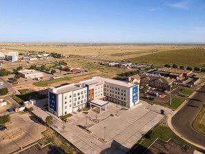 A large building with multiple floors, a parking lot, and a surrounding landscape. - Hampton Inn & Suites Amarillo West (Amarillo)