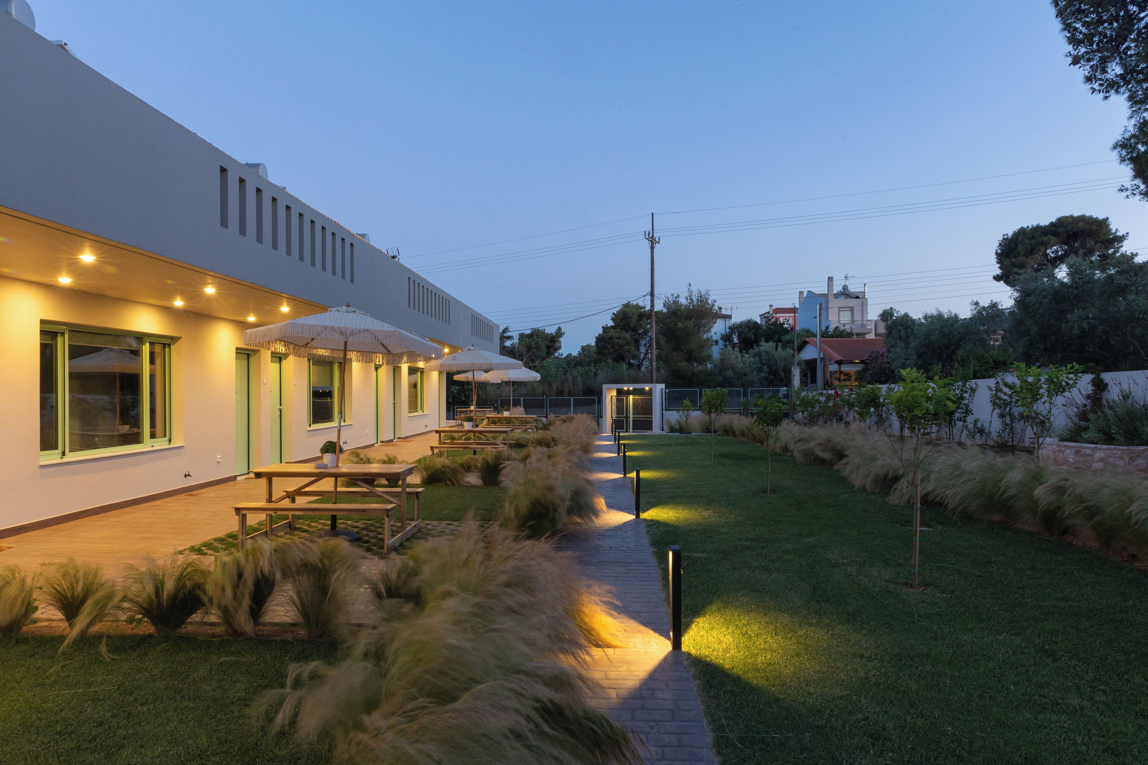 A modern building with outdoor seating and a well-maintained lawn.