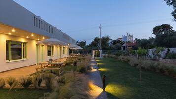 A modern building with outdoor seating and a well-maintained lawn.