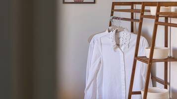A bedroom with a wooden bunk bed, a small wooden stool, and a framed floral artwork on the wall.