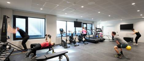 A gym with treadmills, stationary bikes, and weight machines.