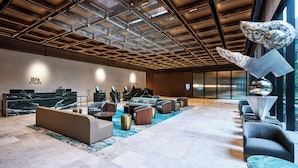 Eine moderne Lobby mit Empfangstresen, einer Sitzecke und einem großen Fenster mit Blick.