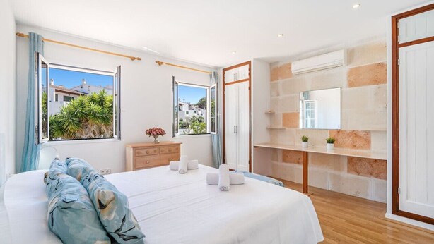 A bedroom with a large bed, a wooden dresser, a mirror, and a view of the outside. - A Midsummer Stay`s Dream (Son Parc)