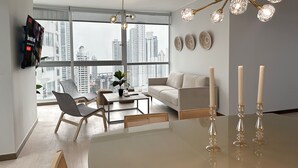Una sala moderna con vista a la ciudad, una mesa de comedor y una araña.