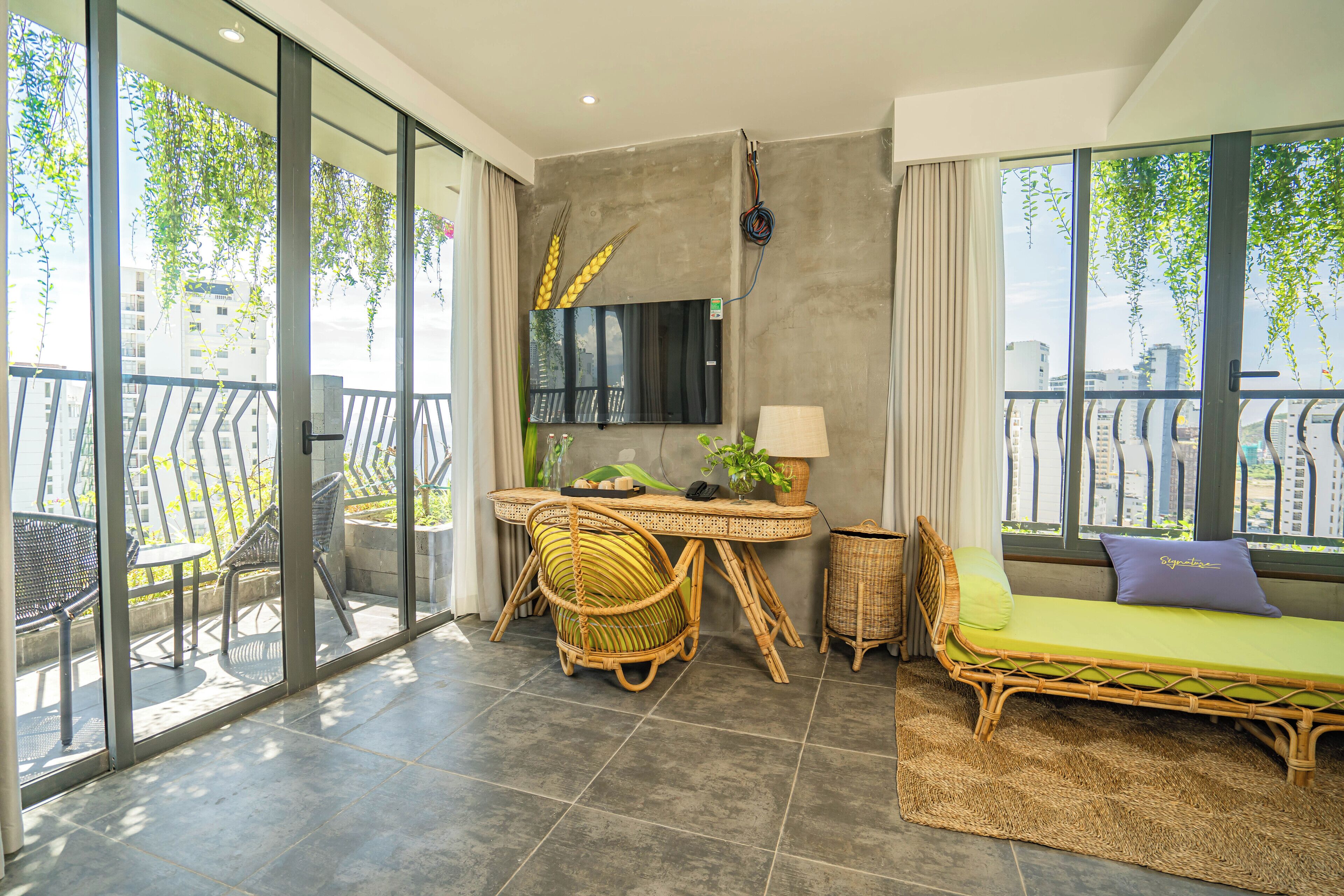 Ein Balkon mit Essbereich, einer Couch und einem Fernseher.