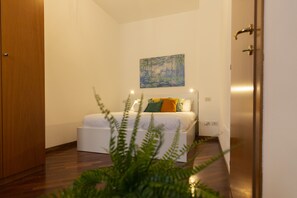 A bedroom with a bed, a painting on the wall, and a wooden door. - notaMi - Urban Retreat - Isola District (Milan)