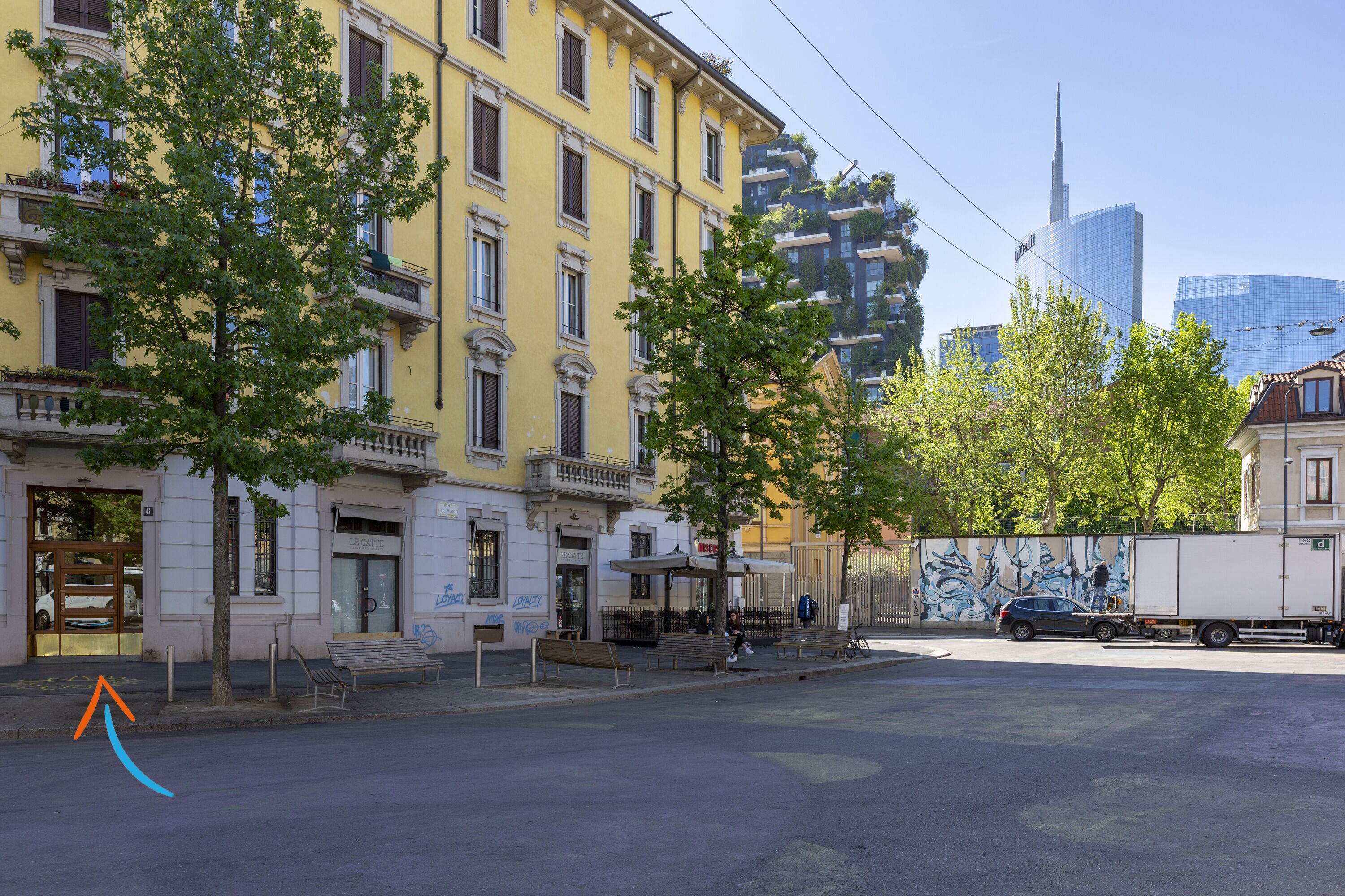 Une rue bordée d’immeubles, d’arbres et où l’on aperçoit un camion.