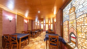Un restaurant avec des tables et des chaises en bois, un sol à carreaux et une fenêtre en vitrail représentant un bâtiment.