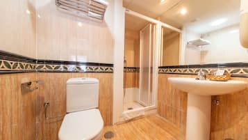 Een badkamer met toilet, douche en wastafel.
