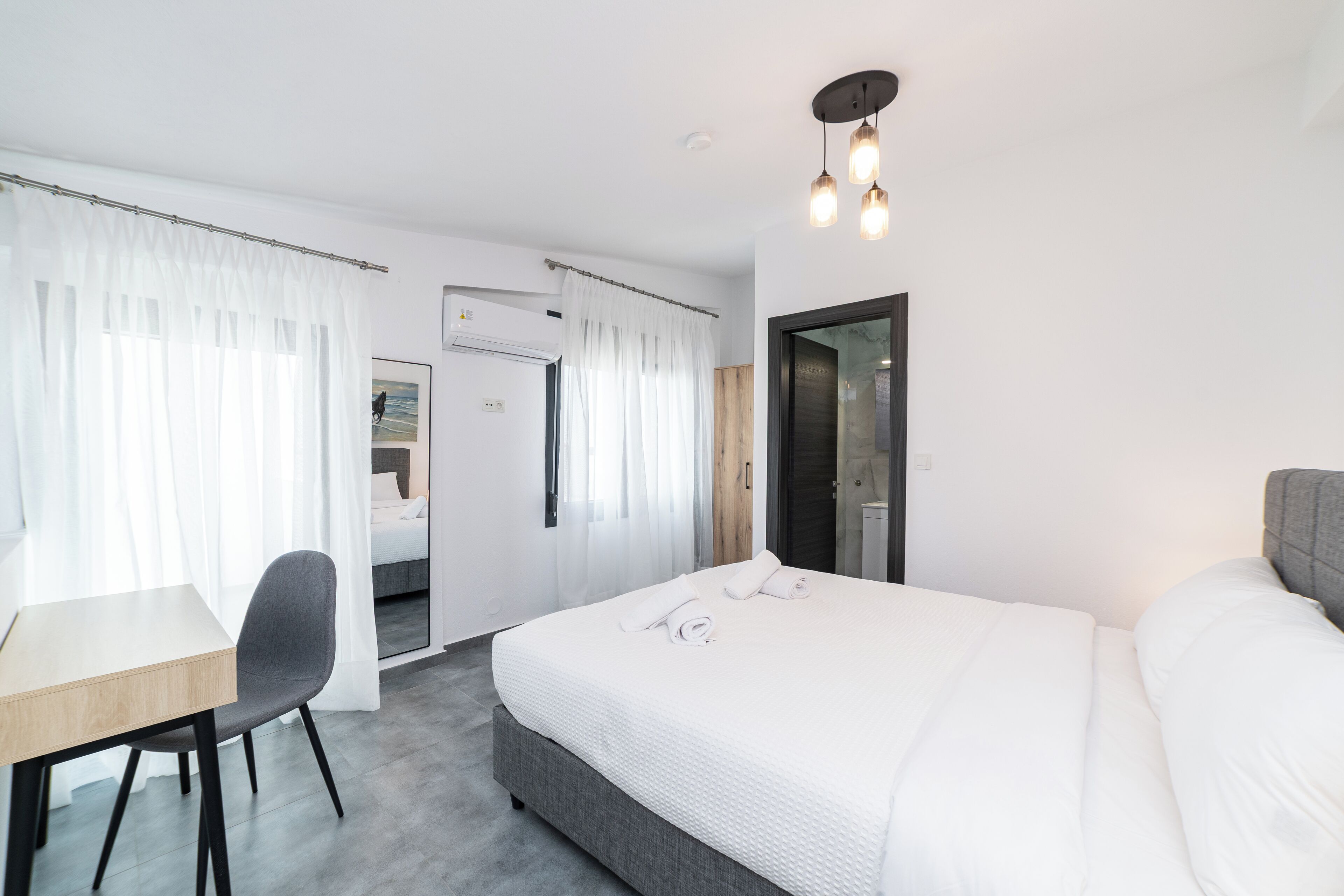 Une chambre d’hôtel moderne, équipée d’un lit, d’un bureau et d’une chaise.