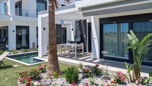 A modern house with a pool, outdoor seating, and a well-maintained garden. - Olympiada Residential Complex & Villas (Pangaio)