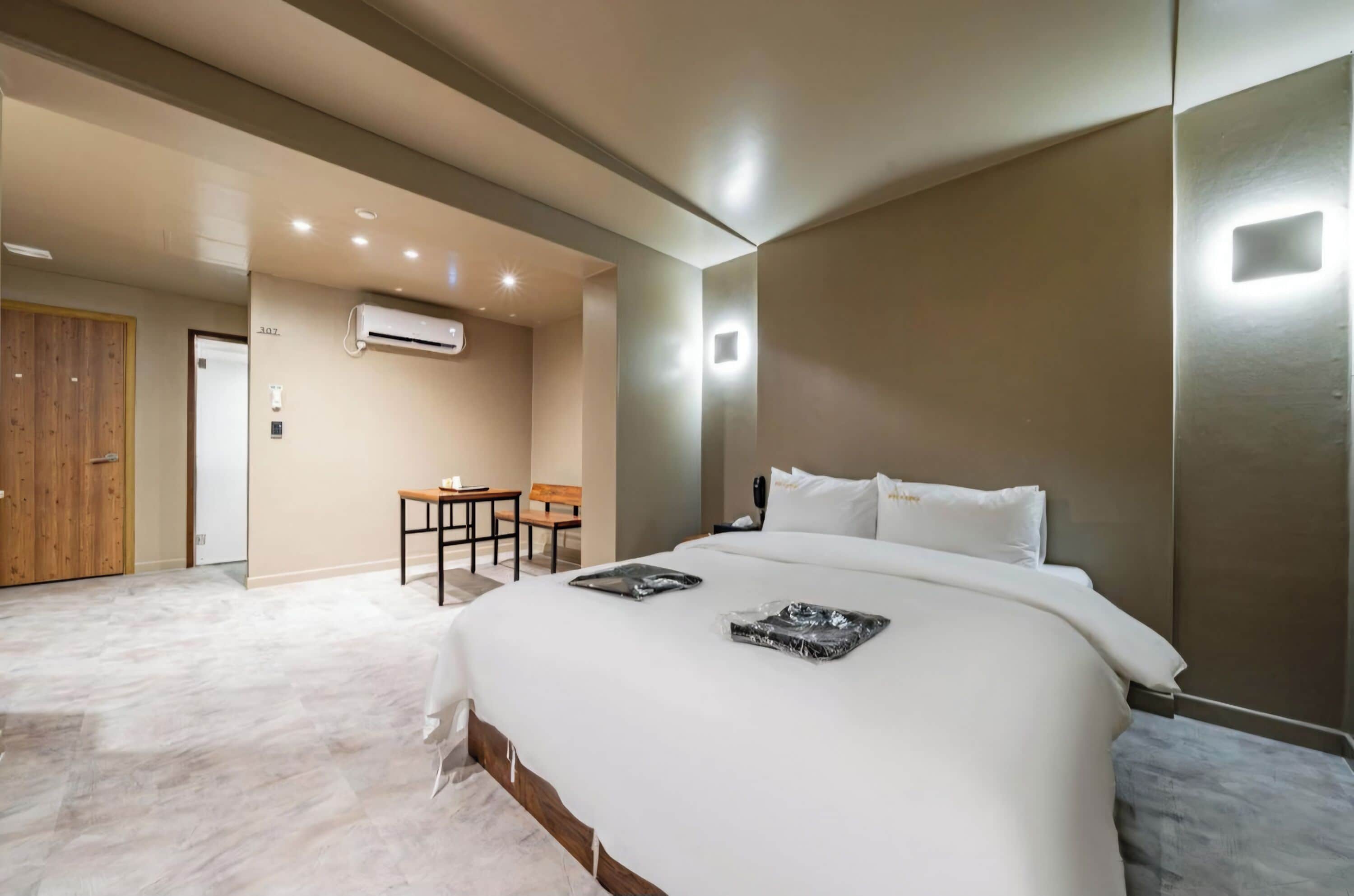 Une chambre d’hôtel moderne avec un grand lit, une petite table et une chaise.