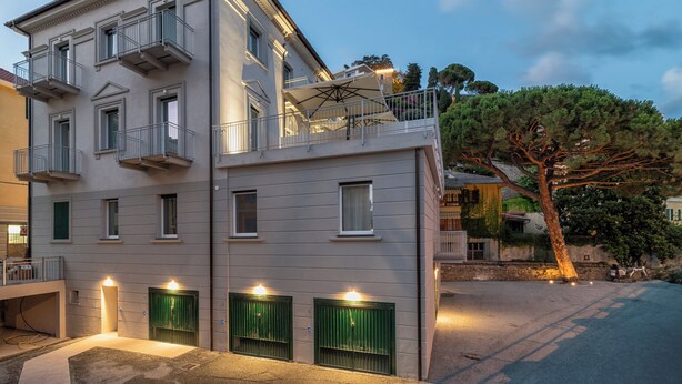 A multi-story building with balconies, green shutters, and outdoor lighting. - Villa Cadiz Apartments Varazze (Varazze)