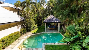 A swimming pool with a gazebo, surrounded by lush greenery and a well-maintained lawn. - Villa Madison | Port Douglas (PORT DOUGLAS)